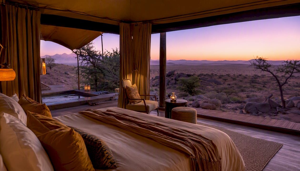 Interior of luxury safari tent with desert and acacia views