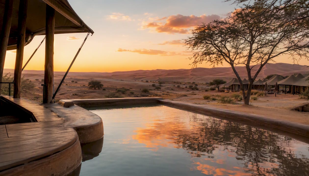 Luxury tented lodge with plunge pool and desert dunes