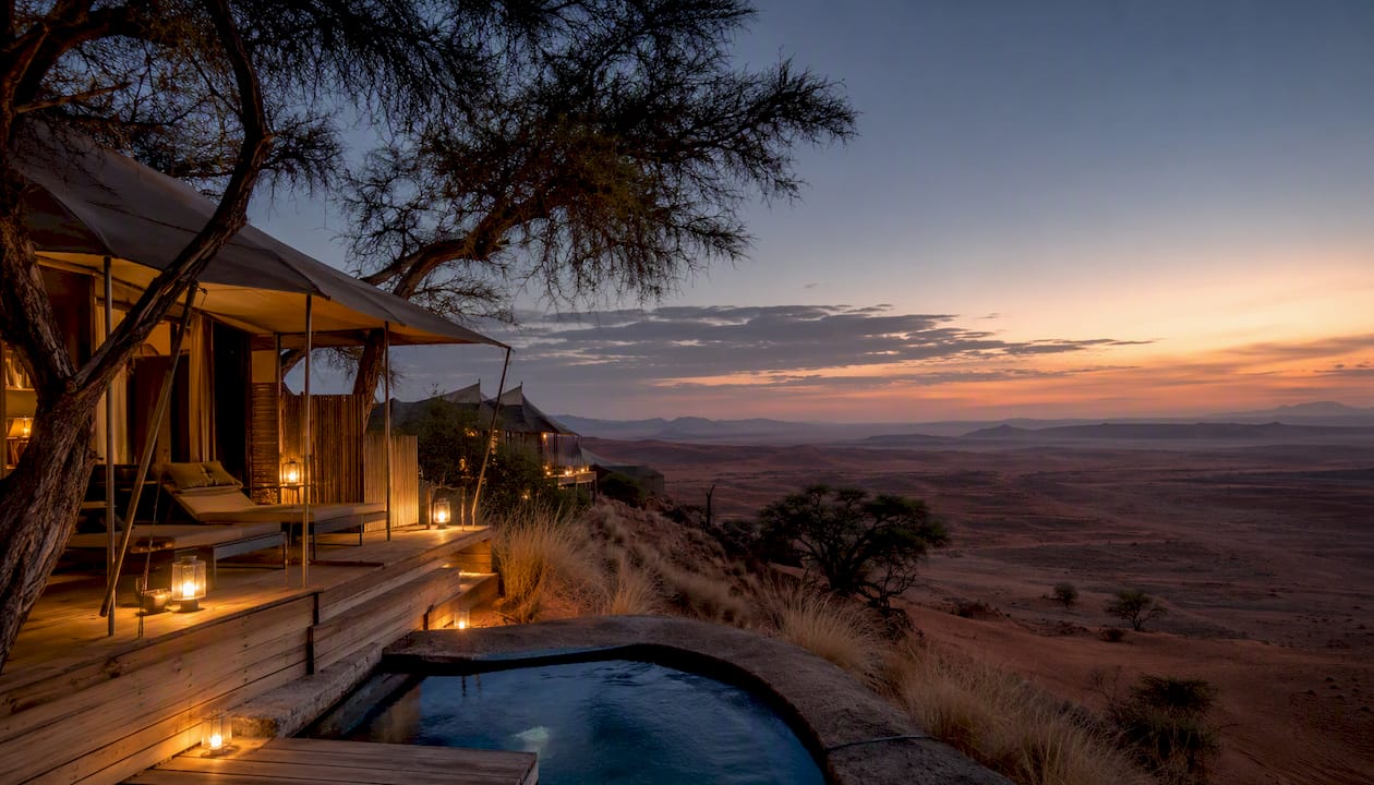 Luxury tented lodge in golden desert at sunset
