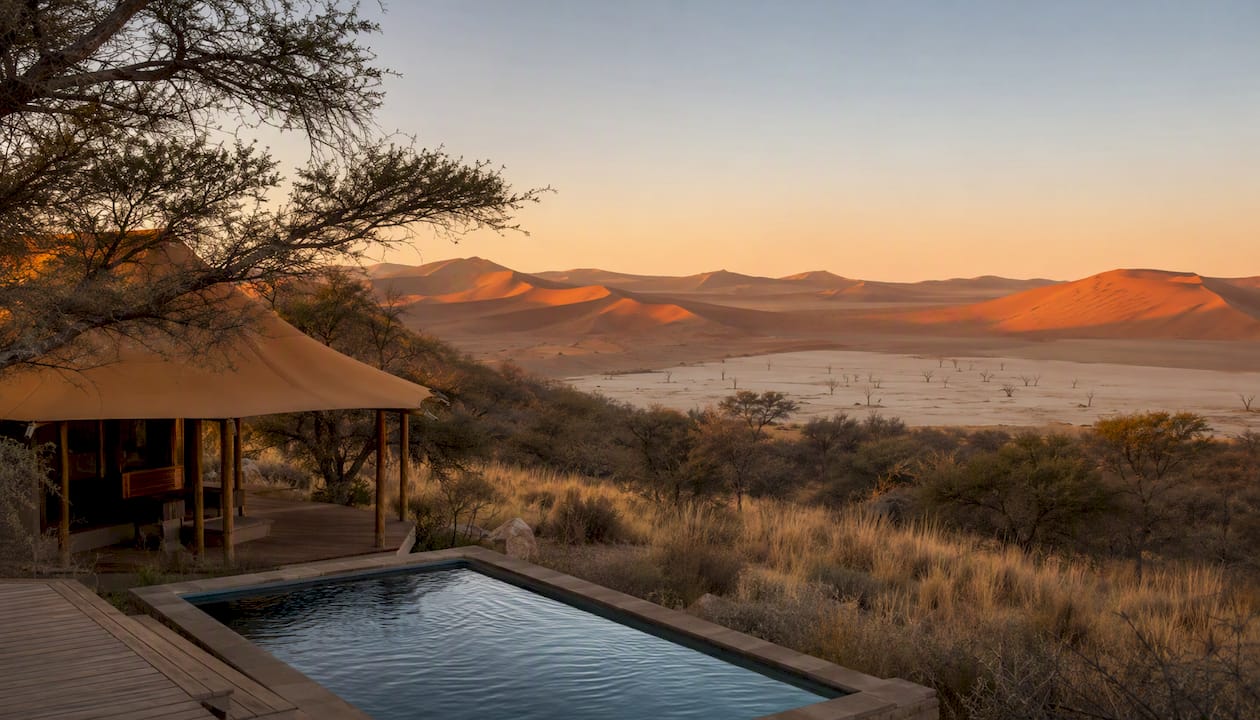 Golden Namib desert dunes and luxury lodge at sunrise