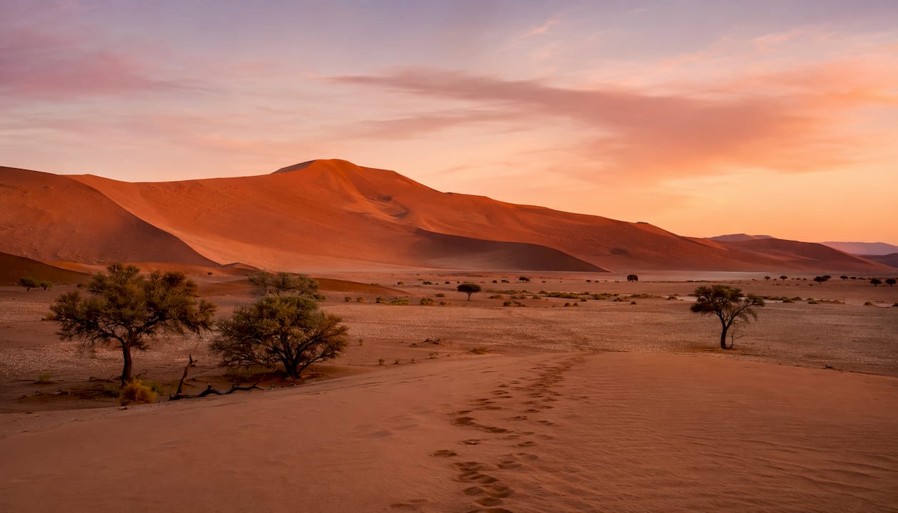 Sunrise over towering red sand dunes