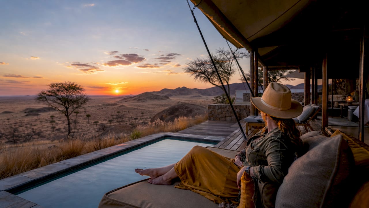Luxury tented lodges with desert dunes at dusk