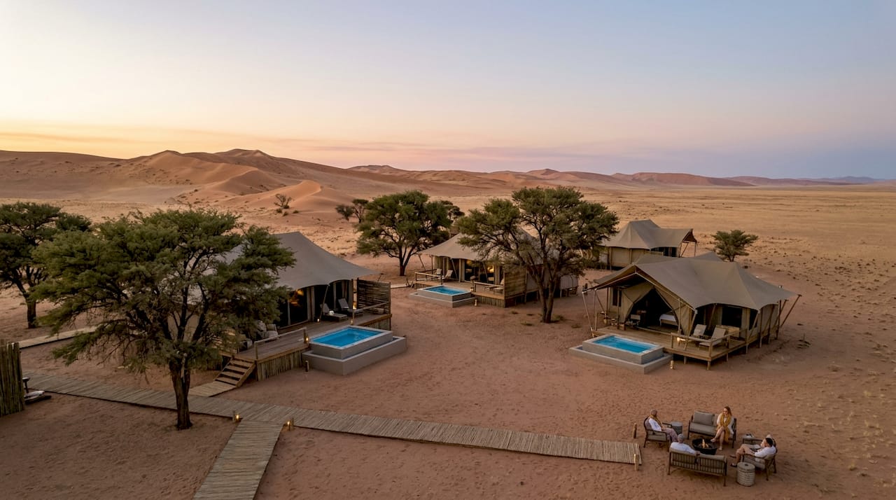 Luxury desert lodges with dune landscape at dusk