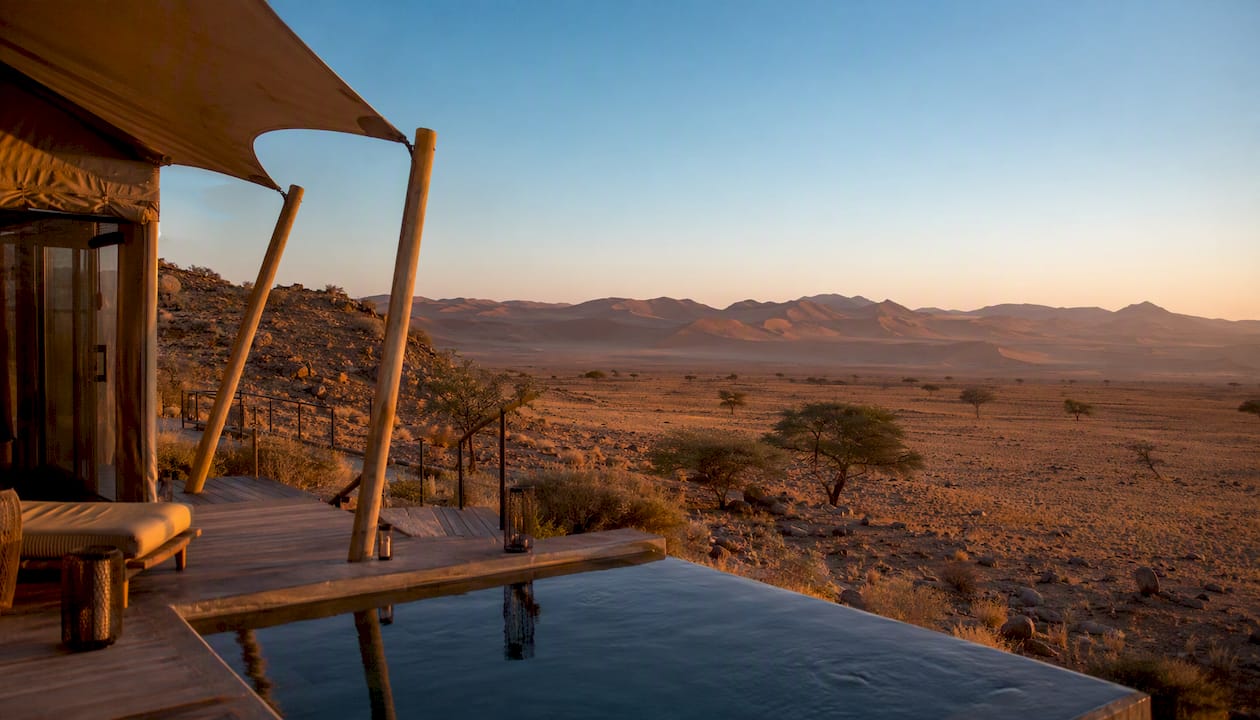 Luxury tented lodge and dunes at sunset