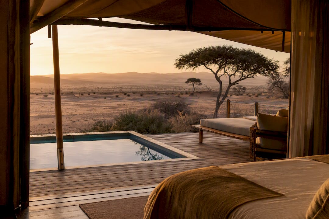 Luxury safari lodge overlooking golden desert dunes at dusk